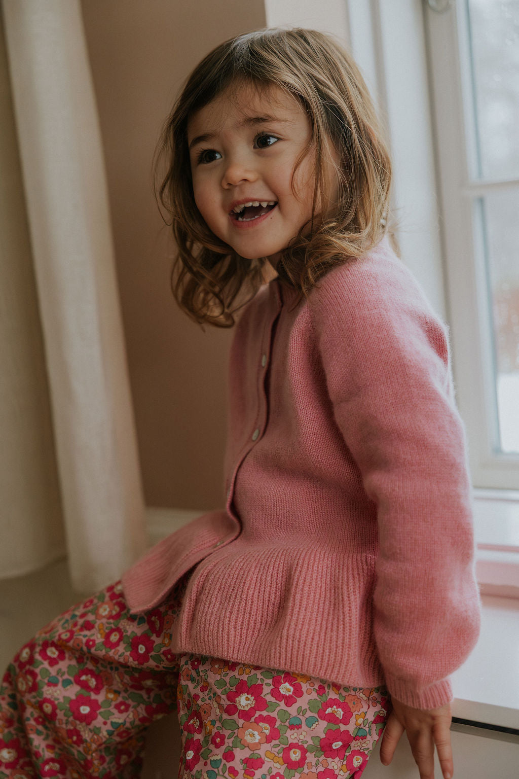 Girl wearing Lalaby Oda cardigan in sorbet pink cashmere
