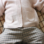Baby girl wearing Lalaby Pixi pants in tweedy check organic cotton