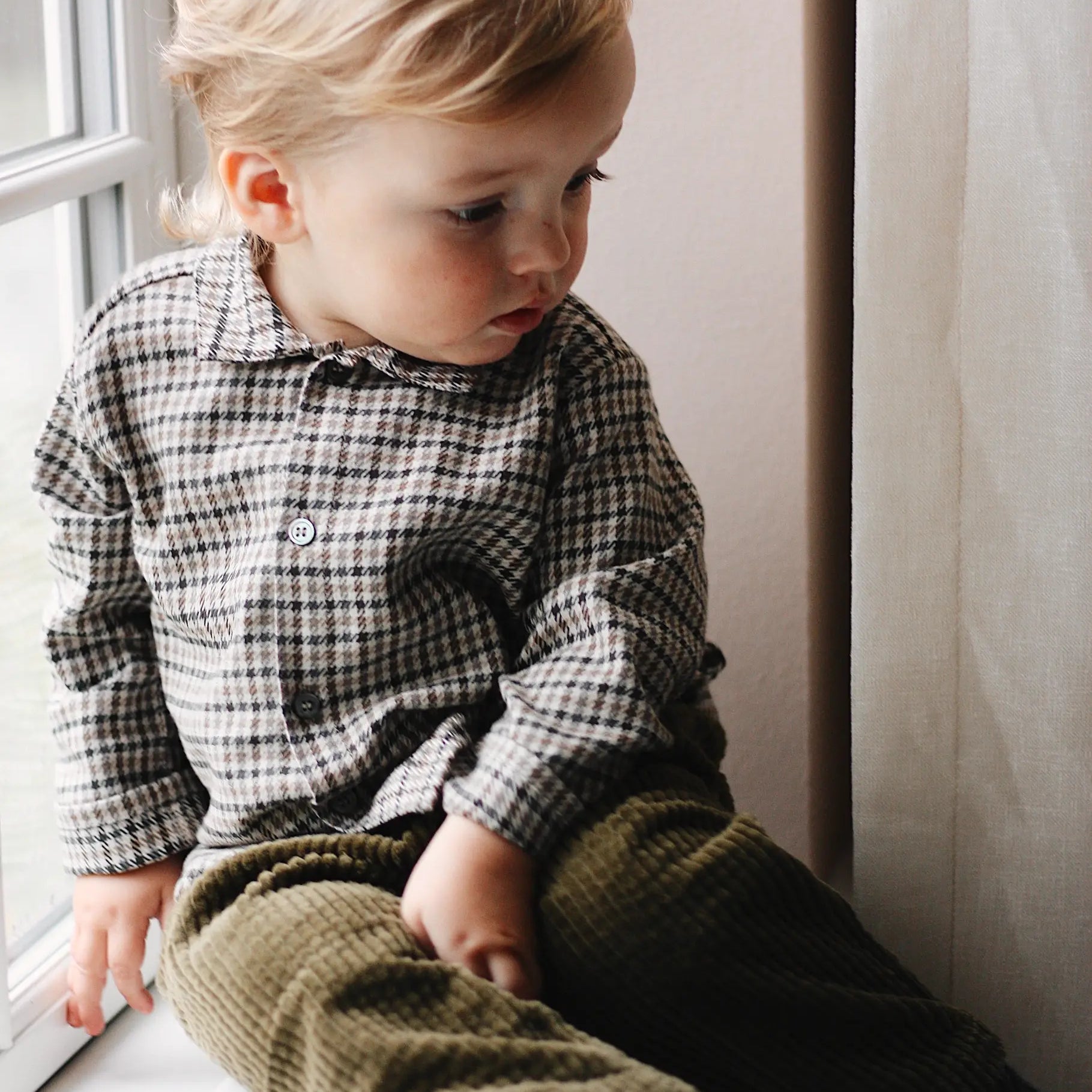 Baby boy wearing Lalaby Saxo baby shirt in tweedy check organic cotton