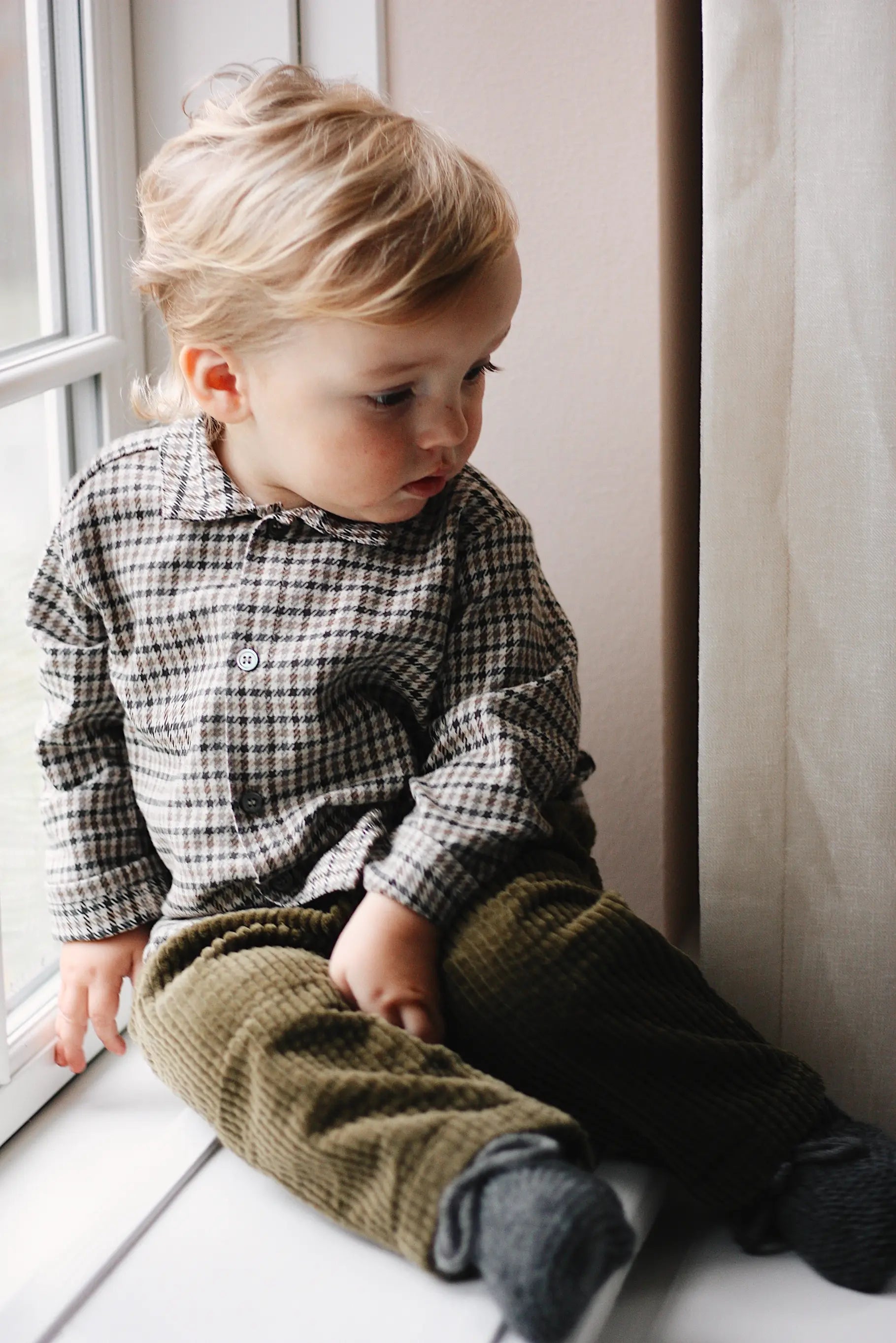 Baby boy wearing Lalaby Saxo baby shirt in tweedy check organic cotton
