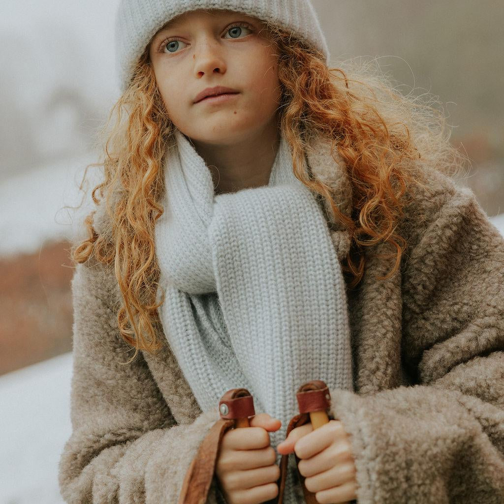 Girl wearing Lalaby Seal scarf and Woody beanie in bluey light blue cashmere