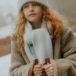 Girl wearing Lalaby Seal scarf and Woody beanie in bluey light blue cashmere