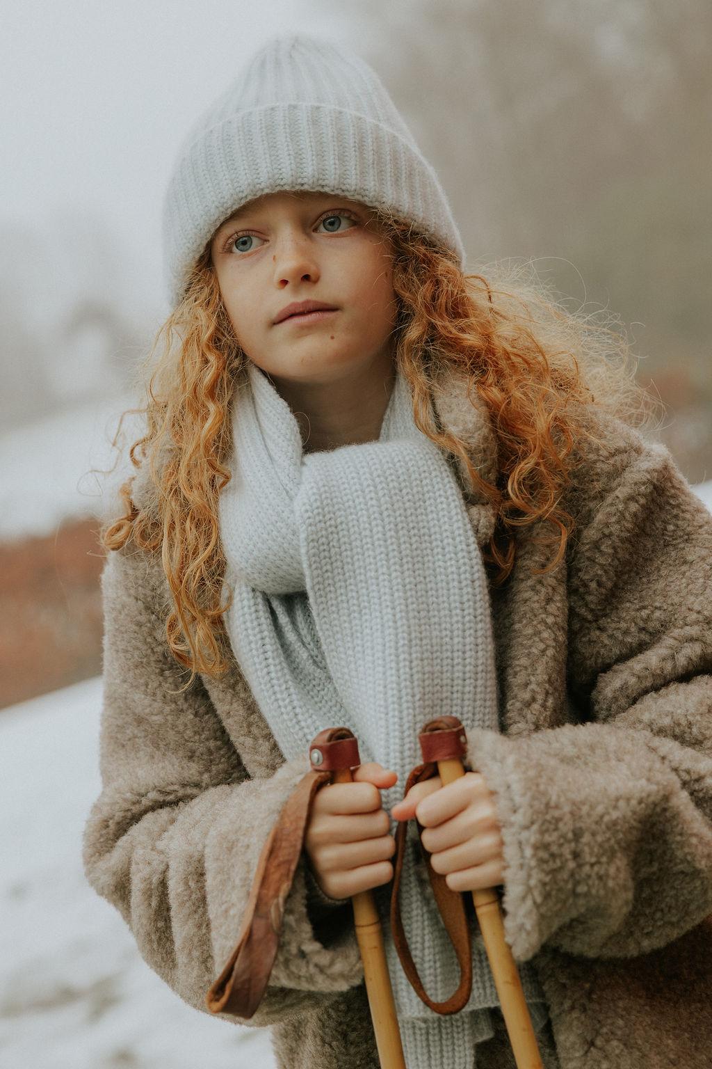 Girl wearing Lalaby Seal scarf and Woody beanie in bluey light blue cashmere