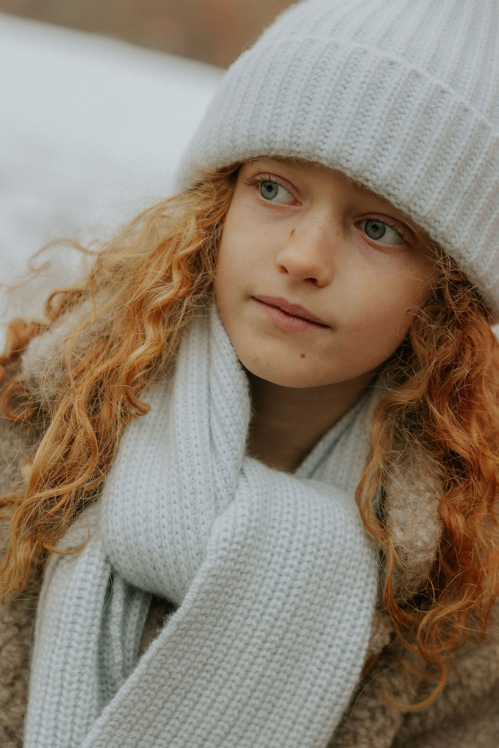 Girl wearing Lalaby Seal scarf and Woody beanie in bluey light blue cashmere