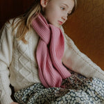 Girl wearing Lalaby Seal scarf in sorbet pink cashmere