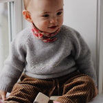 Baby girl wearing Lalaby Sister sweater for babies in a grey baby wool, yak and cashnere blend