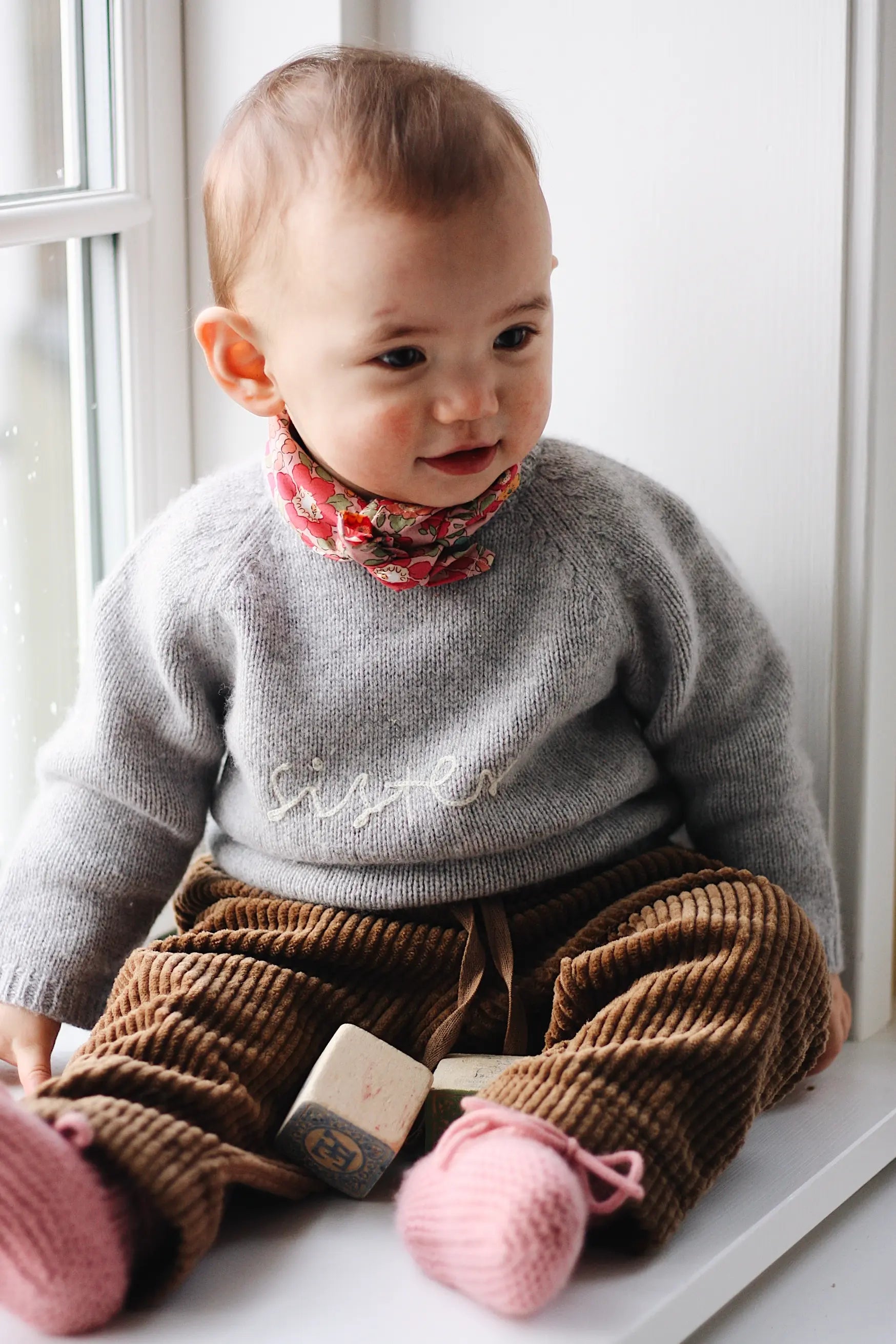 Baby girl wearing Lalaby Sister baby sweater in a grey baby wool, yak and cashmere blend