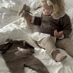 Girl wearing Lalaby Sister sweater for kids and a Aspen jumpsuit for babies in a millet brown baby wool, yak and cashmere blend