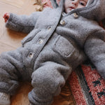 Baby boy wearing Lalaby Teddy baby onesie in elephant grey merino wool