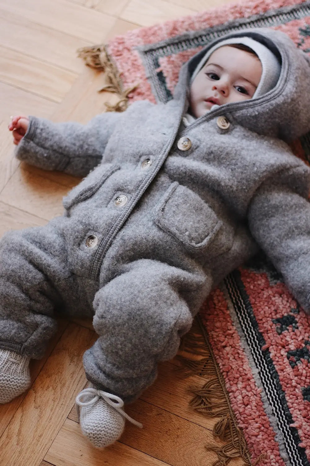 Baby boy wearing Lalaby Teddy baby onesie in elephant grey merino wool