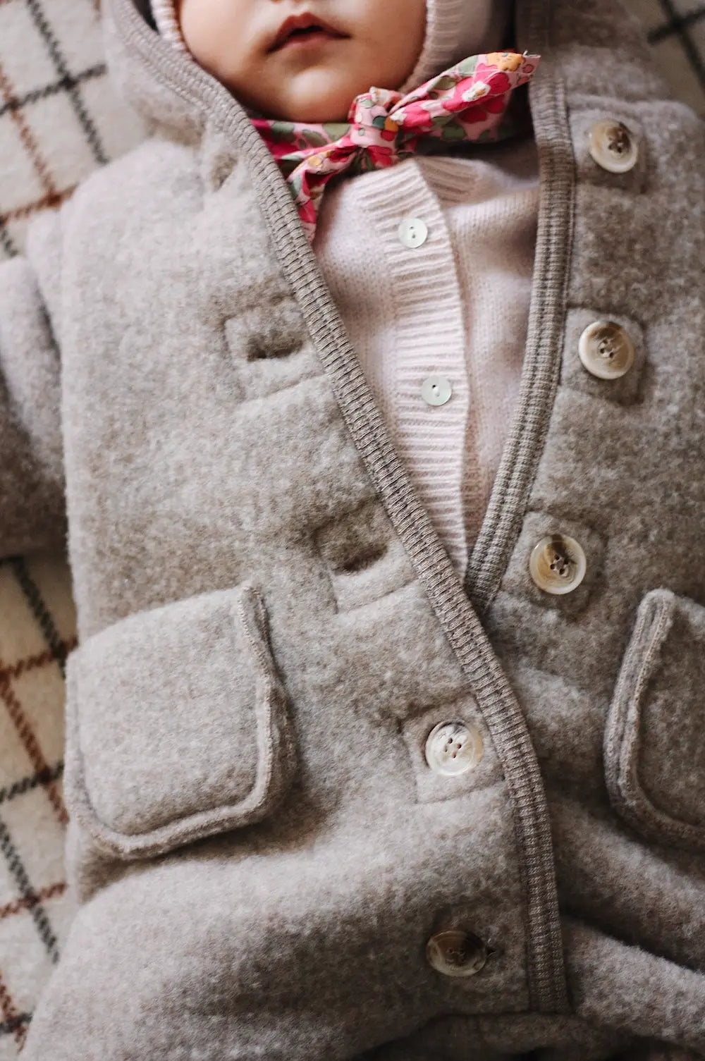 Baby girl wearing Lalaby Teddy baby onesie in hazel brown merino wool