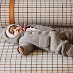 Baby girl wearing Lalaby Teddy baby onesie in hazel brown merino wool