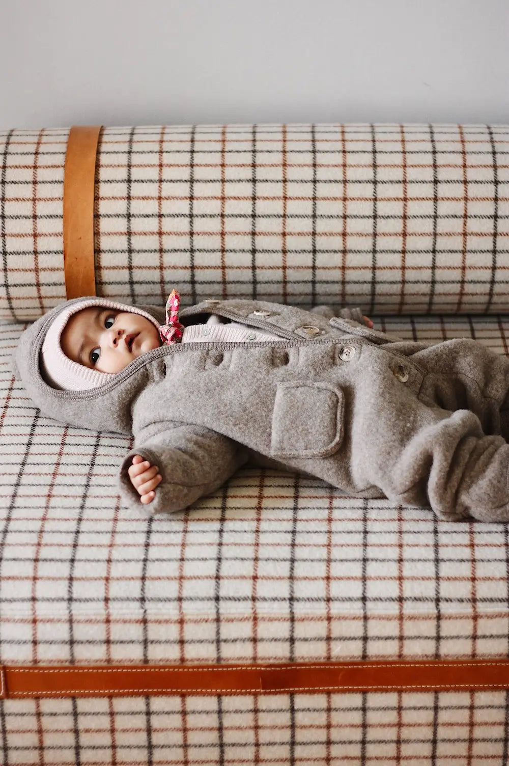 Baby girl wearing Lalaby Teddy baby onesie in hazel brown merino wool