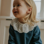 Girl wearing Lalaby Thea kids top in whale blue cotton baby cord