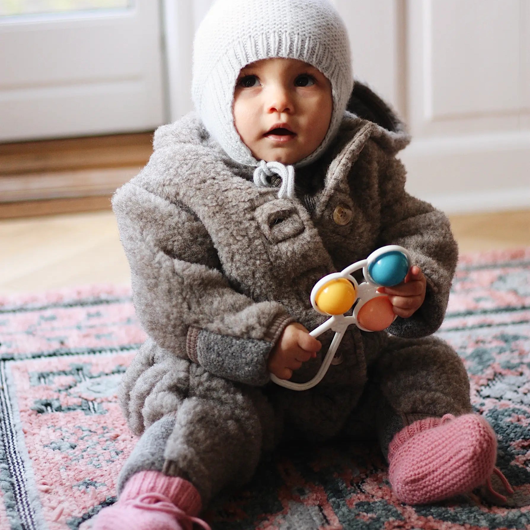 Baby girl wearing Lalaby Thule baby onesie in grizzly brown merino wool