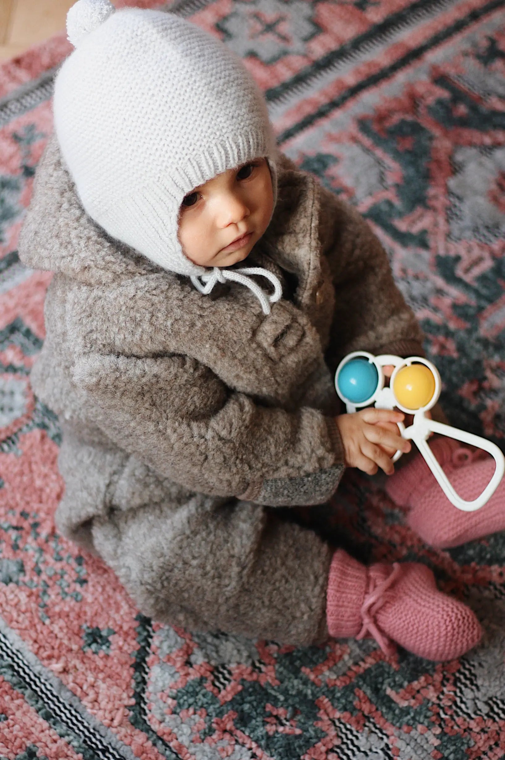 Baby girl wearing Lalaby Thule baby onesie in grizzly brown merino wool