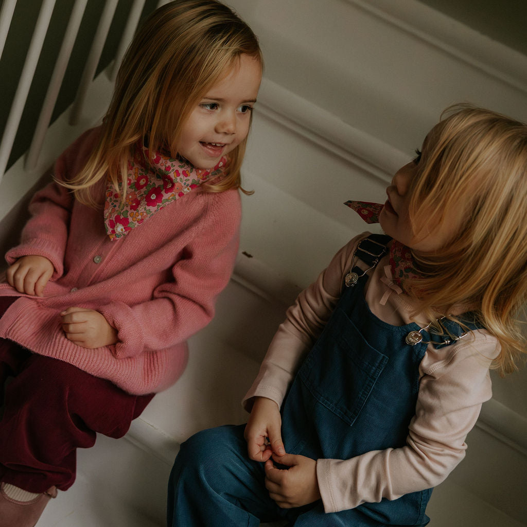 Girls wearing Lalaby Vera scarf for kids and adults in berry betsy pink liberty organic cotton