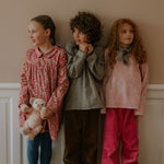 Girl wearing Lalaby Vera scarf for kids and adults in tweedy check organic cotton