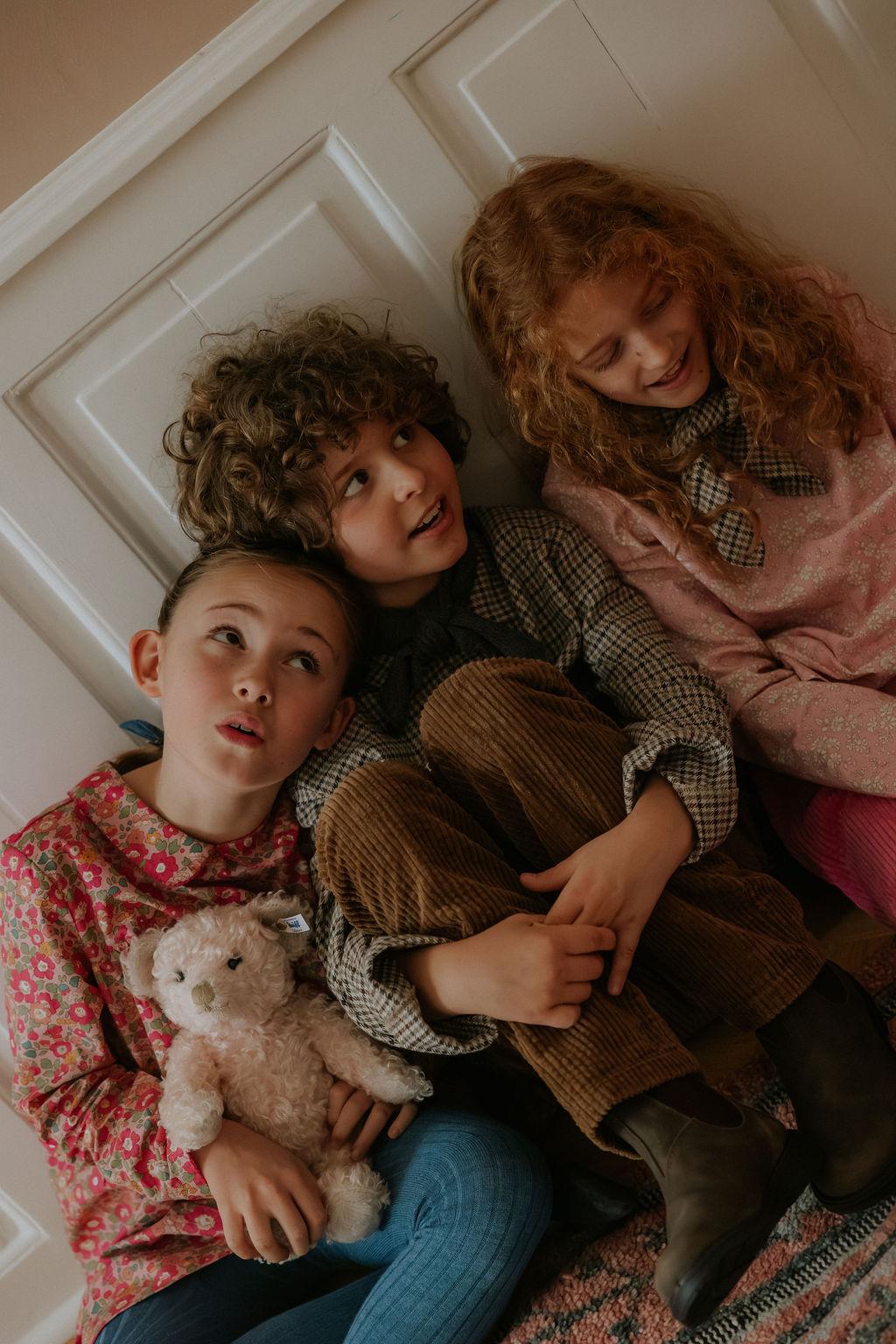 Girl wearing Lalaby Vera scarf for kids and adults in tweedy check organic cotton