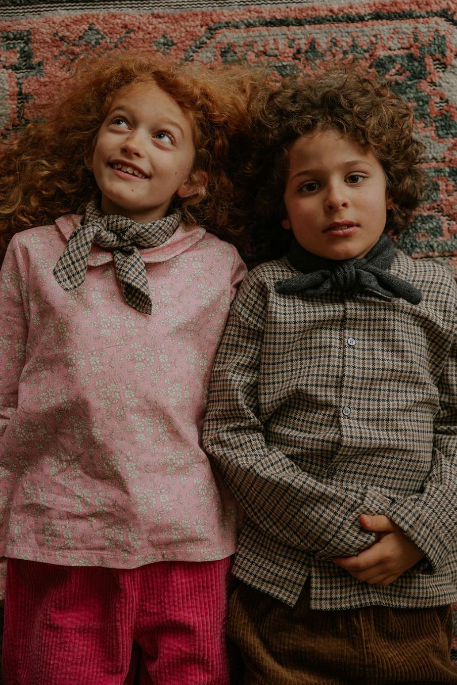 Girl wearing Lalaby Vera scarf for kids and adults in tweedy check organic cotton