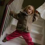 Girl wearing Lalaby Vera scarf for kids and adults in tweedy check organic cotton