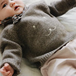 Baby girl wearing Lalaby Winnie jumper for babies in a millet brown baby wool, yak and cashmere blend 