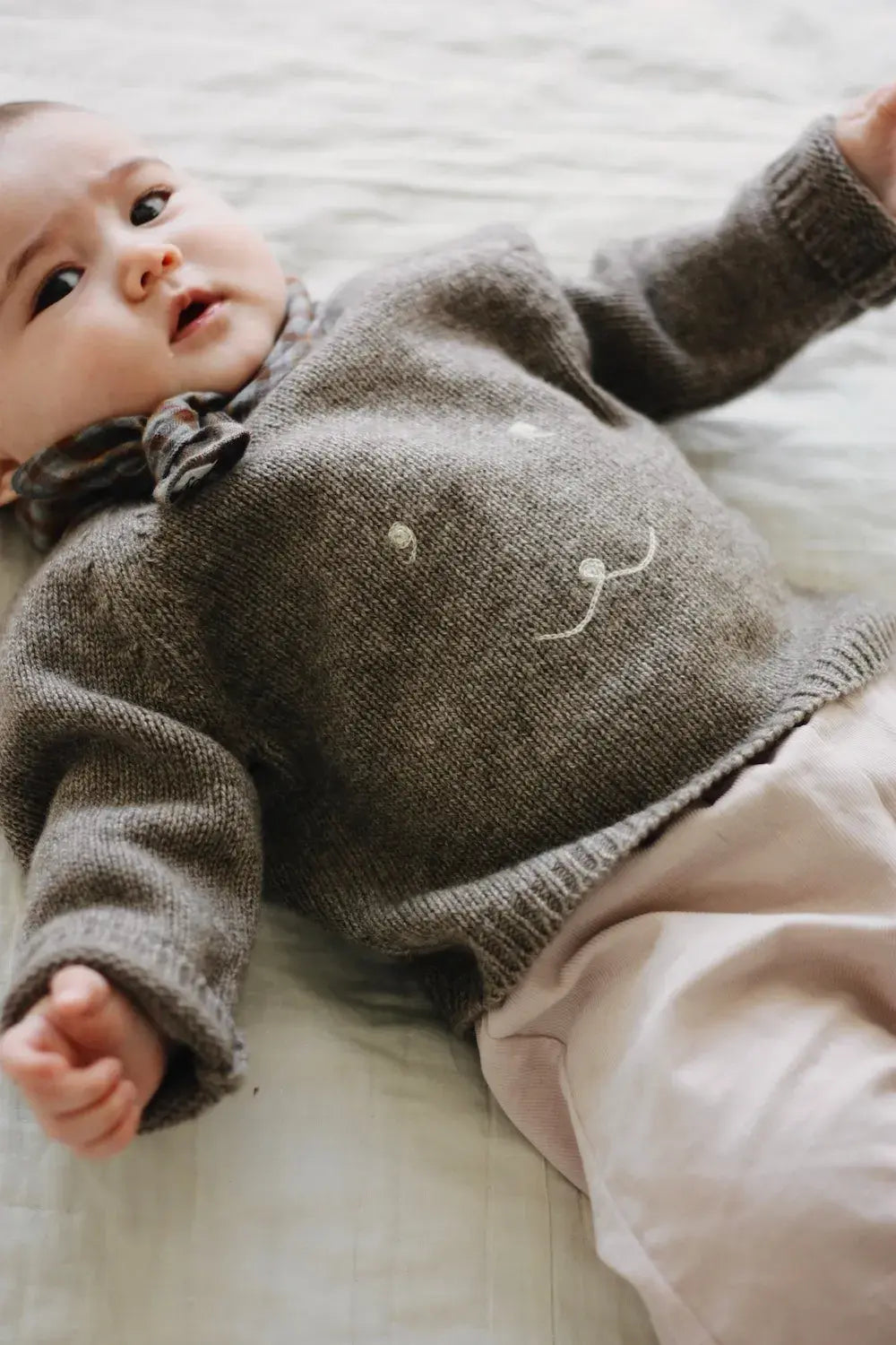 Baby girl wearing Lalaby Winnie jumper for babies in a millet brown baby wool, yak and cashmere blend 