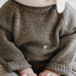 Baby girl wearing Lalaby Winnie jumper for babies in a millet brown baby wool, yak and cashmere blend 