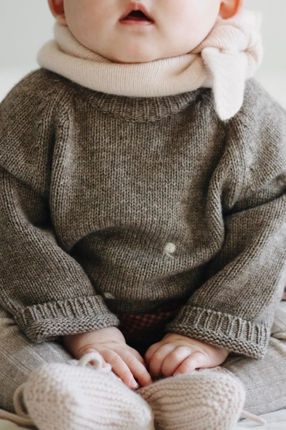 Baby girl wearing Lalaby Winnie jumper for babies in a millet brown baby wool, yak and cashmere blend 