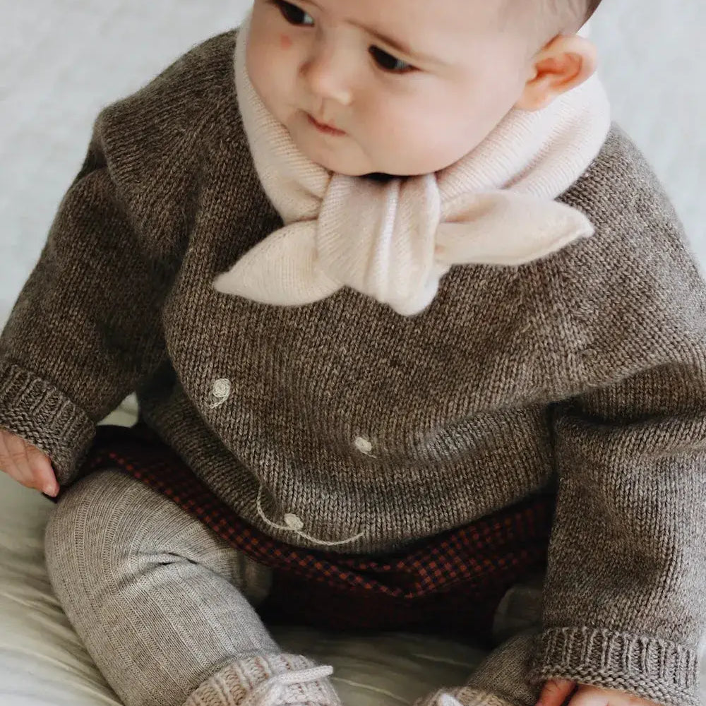 Baby girl wearing Lalaby Winnie jumper for babies in a millet brown baby wool, yak and cashmere blend 