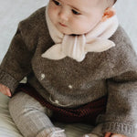 Baby girl wearing Lalaby Winnie jumper for babies in a millet brown baby wool, yak and cashmere blend 