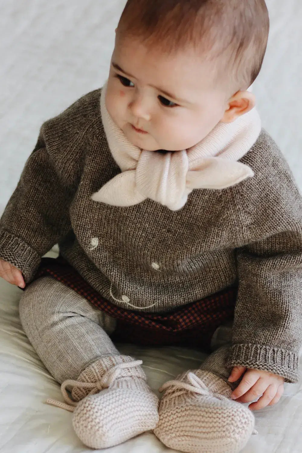 Baby girl wearing Lalaby Winnie jumper for babies in a millet brown baby wool, yak and cashmere blend 