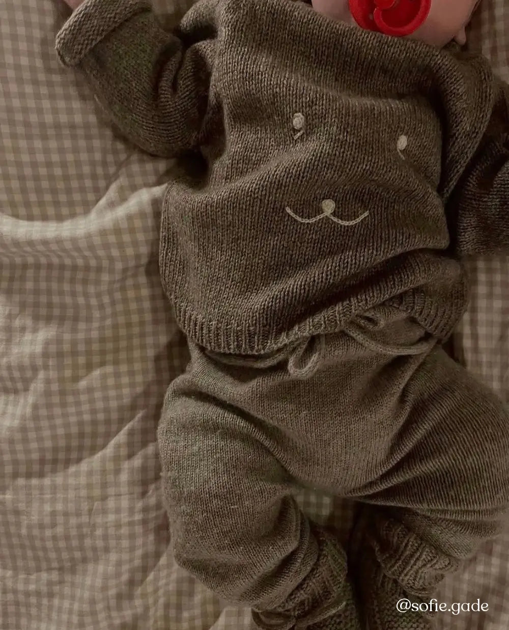 Baby wearing Lalaby Winnie jumper for babies in a millet brown baby wool, yak and cashmere blend 